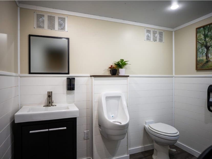 Inside the two-station trailer: a real vanity, porcelain fixtures, framed art, and finished walls, from the site's own gallery.